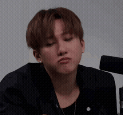 A Young Man In A Black Jacket Is Making A Funny Face With His Eyes Closed . GIF