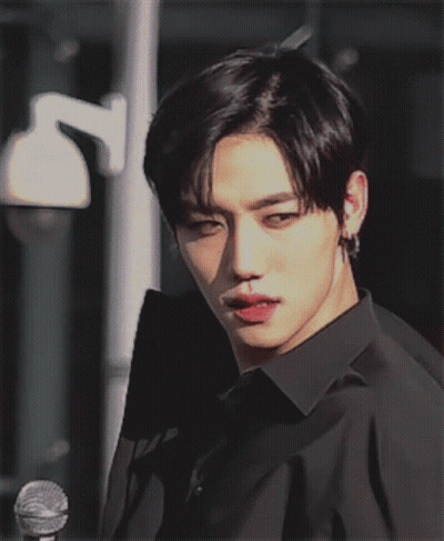 A Young Man In A Black Shirt Is Looking At The Camera GIF