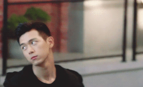 A Young Man In A Black Shirt Is Looking To The Side GIF