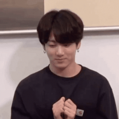 A Young Man In A Black Shirt Is Making A Heart With His Hands . GIF
