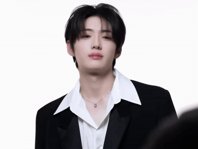 A Young Man In A Black Suit And White Shirt GIF
