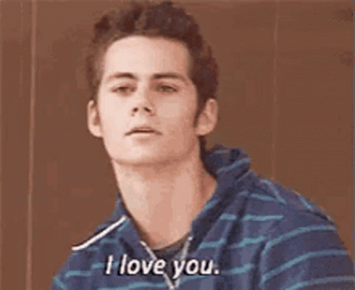 A Young Man In A Blue And White Striped Shirt Is Sitting Down And Saying `` I Love You '' . GIF
