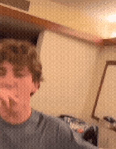 A Young Man In A Blue Shirt Is Making A Face GIF