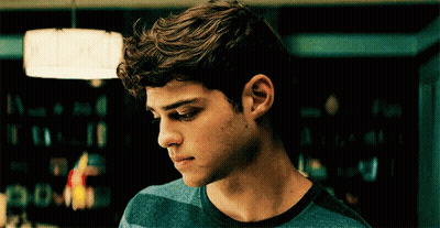 A Young Man In A Blue Striped Shirt Looks Down GIF