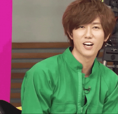 A Young Man In A Green Jacket Is Smiling GIF