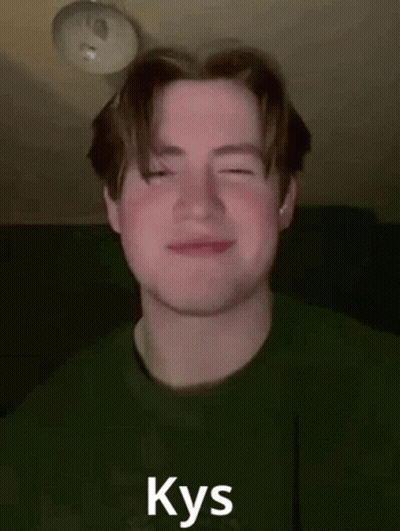 A Young Man In A Green Shirt Is Smiling With His Eyes Closed And The Word Kys Written On His Face . GIF