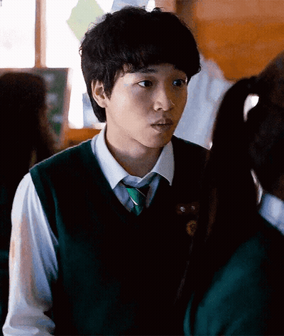 A Young Man In A Green Vest And Tie Is Looking At A Girl GIF