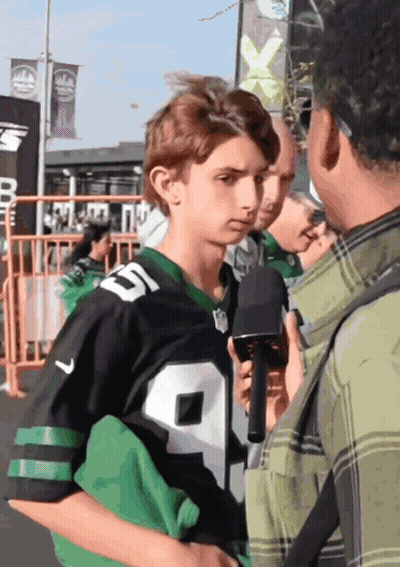 A Young Man In A Jets Jersey Is Being Interviewed By A Man Holding A Microphone GIF
