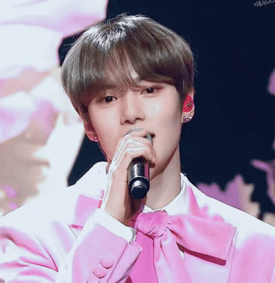 A Young Man In A Pink Suit Sings Into A Microphone GIF