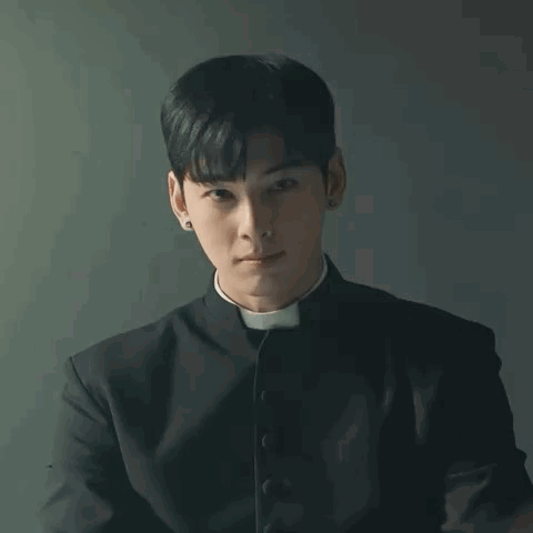 A Young Man In A Priest 'S Robe Is Praying With His Hands Together . GIF