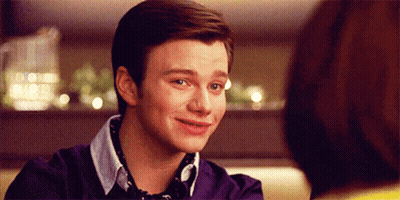 A Young Man In A Purple Sweater Is Smiling GIF
