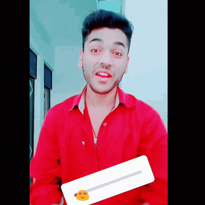 A Young Man In A Red Shirt Is Holding A Sticker With A Yellow Face On It GIF