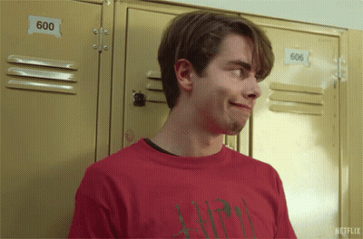 A Young Man In A Red Shirt Is Standing In Front Of Lockers With The Number 600 On Them GIF