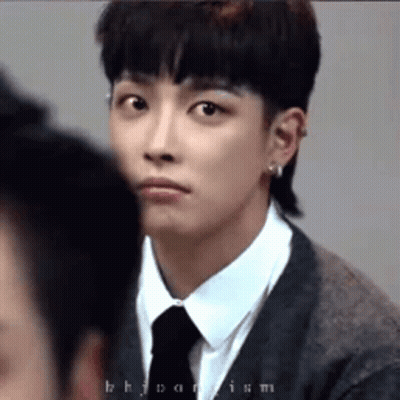 A Young Man In A Suit And Tie Is Looking At Another Man . GIF