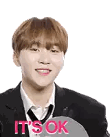 A Young Man In A Suit And Tie Is Smiling While Holding A Sign That Says It 'S Ok . Sticker