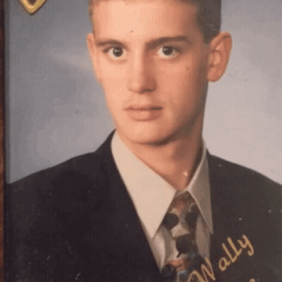 A Young Man In A Suit And Tie With The Name Wally GIF