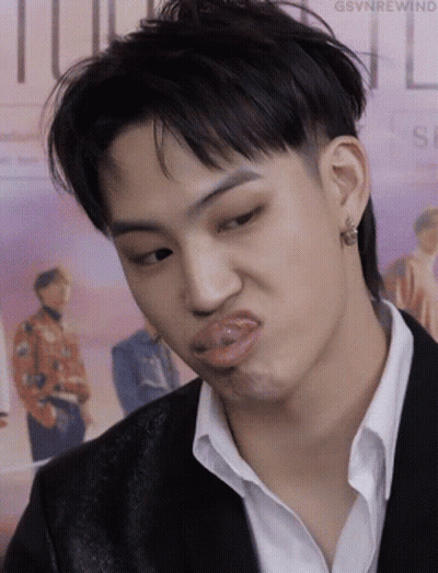 A Young Man In A Suit And White Shirt Is Making A Funny Face . GIF