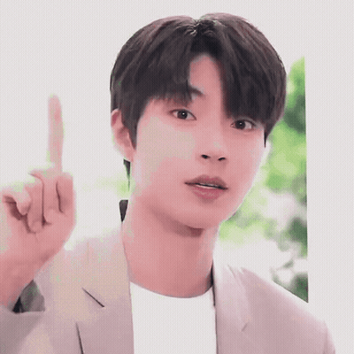 A Young Man In A Suit Is Pointing His Finger Up . GIF