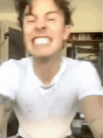 A Young Man In A White Shirt Is Making A Funny Face . GIF