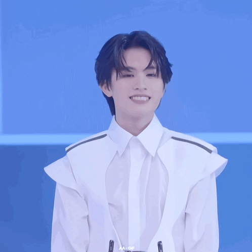 A Young Man In A White Shirt With Aa Written On The Bottom Right GIF