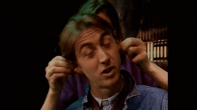 A Young Man Is Covering His Ears With His Hands While Making A Funny Face . GIF