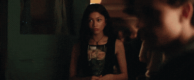 A Young Man Is Drinking From A Red Cup In A Room . GIF