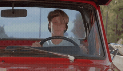 A Young Man Is Driving A Red Truck With The Hood Open . GIF