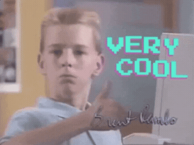 A Young Man Is Giving A Thumbs Up In Front Of A Computer Screen That Says " Very Cool " GIF