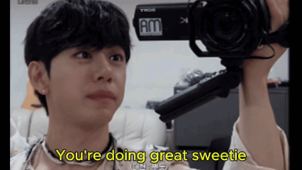 A Young Man Is Holding A Camera And Says " You 'Re Doing Great Sweetie " In Yellow Letters GIF