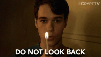 A Young Man Is Holding A Lit Match In Front Of His Face And Says `` Do Not Look Back '' . GIF
