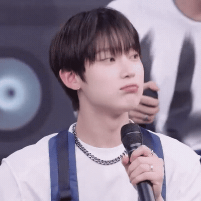A Young Man Is Holding A Microphone In His Hand . GIF