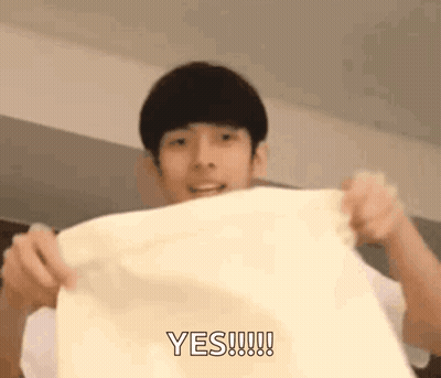 A Young Man Is Holding A Piece Of Paper In His Hands And Says Yes . GIF
