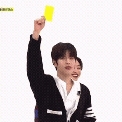 A Young Man Is Holding Up A Yellow Card In A Foreign Language . GIF