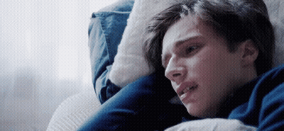 A Young Man Is Laying On A Couch With His Head On A Pillow . GIF