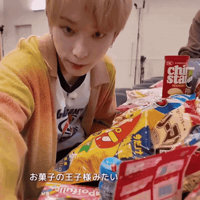 A Young Man Is Looking At A Bag Of Chips That Says Chi Star On It GIF