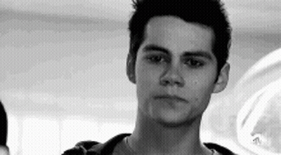 A Young Man Is Looking At The Camera In A Black And White Photo . GIF