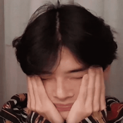 A Young Man Is Making A Face With His Hands . GIF