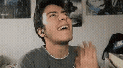 A Young Man Is Making A Funny Face And Clapping His Hands . GIF