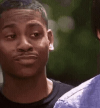 A Young Man Is Making A Funny Face While Looking At Another Man . GIF