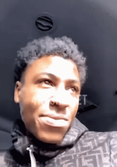 A Young Man Is Making A Funny Face While Sitting In The Back Of A Car . GIF