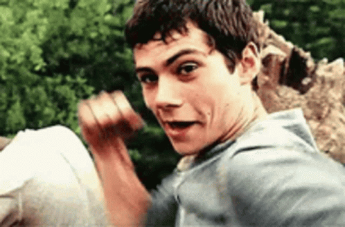 A Young Man Is Making A Funny Face While Standing In Front Of A Giraffe . GIF