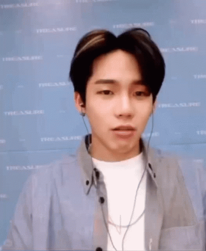 A Young Man Is Making A Funny Face While Wearing Headphones And A Blue Shirt . GIF