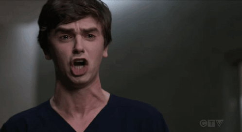 A Young Man Is Making A Funny Face With His Mouth Wide Open . GIF