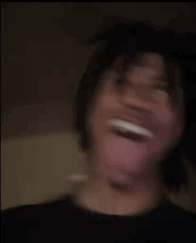 A Young Man Is Making A Funny Face With His Tongue Out . GIF