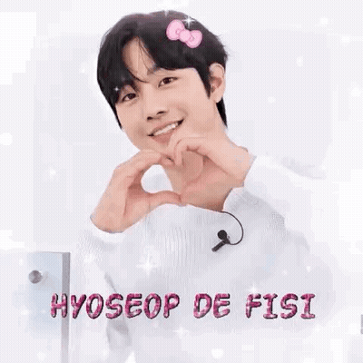 A Young Man Is Making A Heart Shape With His Hands While Wearing A Hello Kitty Headband . GIF
