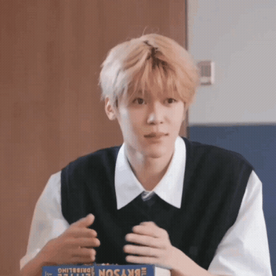 A Young Man Is Sitting At A Table With A Box Of Skyson GIF