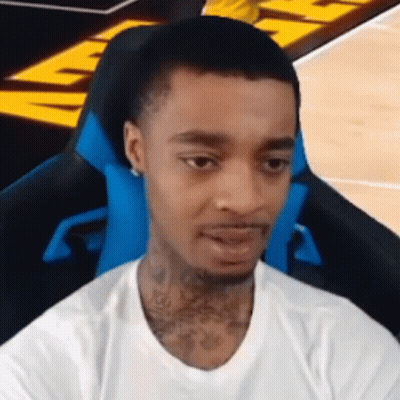 A Young Man Is Sitting In A Blue Chair On A Basketball Court . GIF