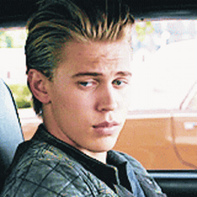 A Young Man Is Sitting In A Car Looking Out The Window GIF