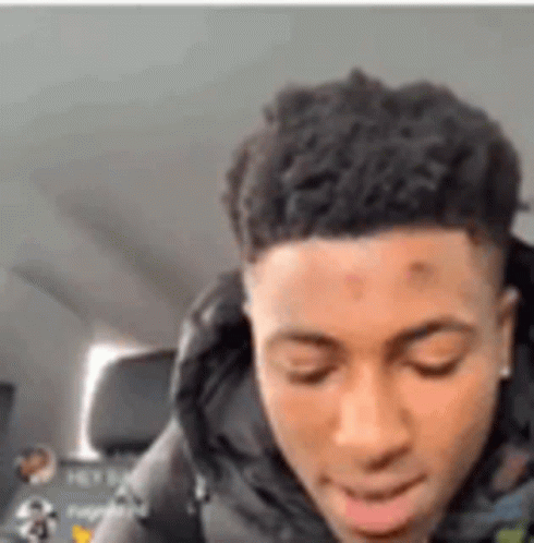 A Young Man Is Sitting In A Car With His Eyes Closed And His Mouth Open . GIF