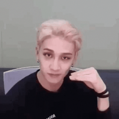 A Young Man Is Sitting In A Chair Making A Funny Face . GIF